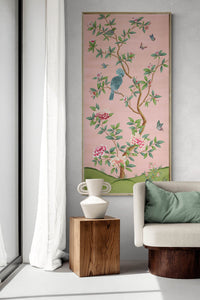 framed pink and green chinoiserie wall art panel with botanical illustrations featuring birds, butterflies, and flowers hung on wall