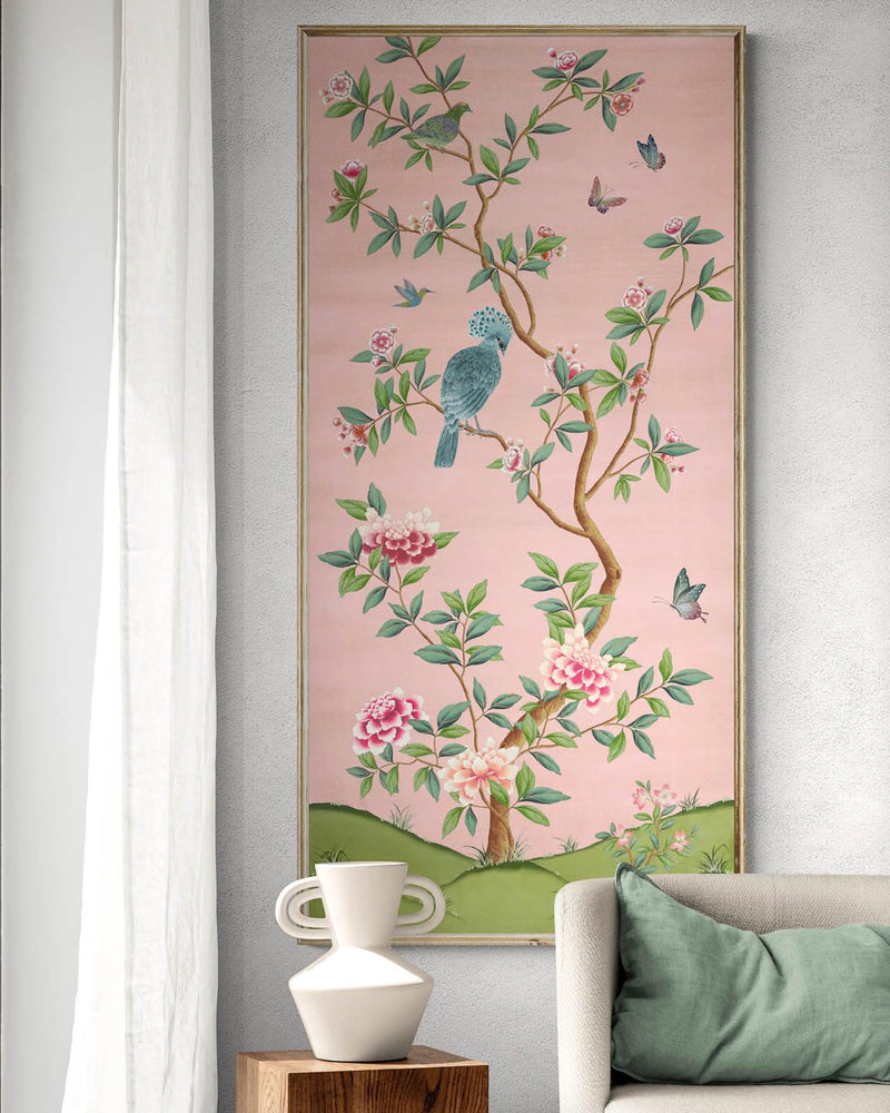 framed pink and green chinoiserie wall art panel with botanical illustrations featuring birds, butterflies, and flowers hung on wall