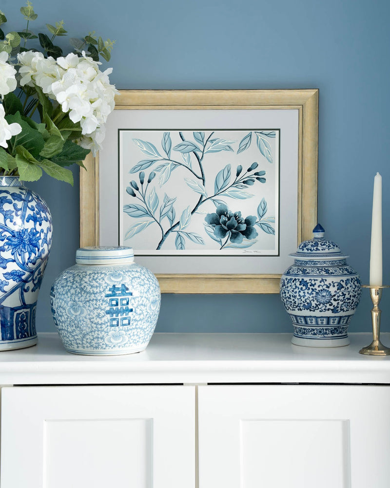 framed classic blue and white chinoiserie art print featuring flowers and branches with gold embellishment in regency style living room