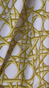 close up of yellow geometric fabric featuring chinoiserie trellis design