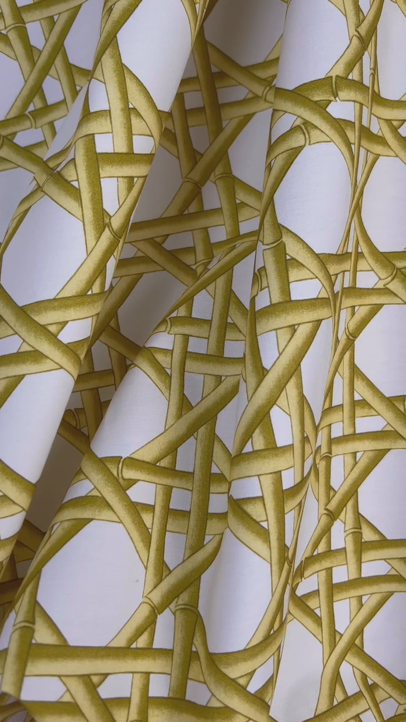 close up of yellow geometric fabric featuring chinoiserie trellis design