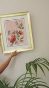 framed pink chinoiserie art print featuring butterflies and flowers being placed on wall