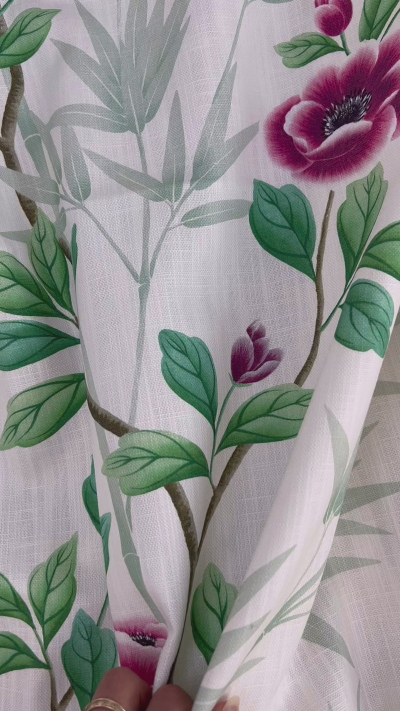 close up of white and green floral fabric featuring chinoiserie style bamboo and flowers