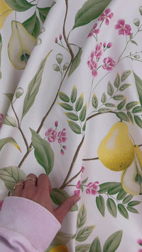 close up of yellow botanical fabric featuring chinoiserie style fruits and flowers