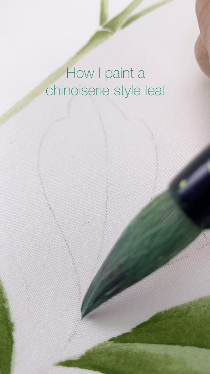 up close video of diane hill painting a chinoiserie style leaf using green gouache paint and chinoiserie brushes onto silk paper
