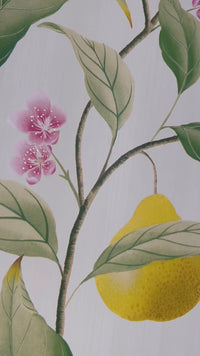 close up of yellow botanical wallpaper featuring chinoiserie style fruits and flowers