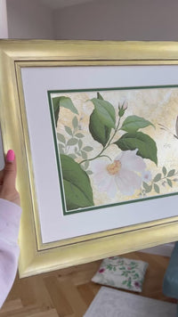 Video of Diane Hill holding her original chinoiserie painting 'Mottled Dog Rose And Butterfly' in a gold frame glistening as it catches the light