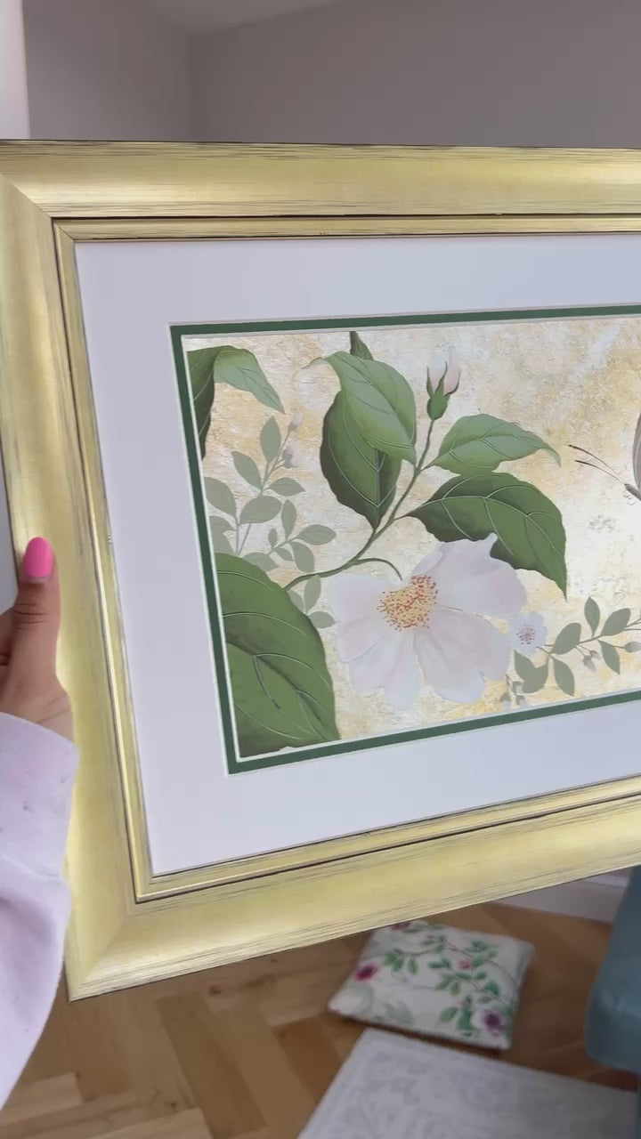 Video of Diane Hill holding her original chinoiserie painting 'Mottled Dog Rose And Butterfly' in a gold frame glistening as it catches the light