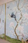 close up of 2 framed blue chinoiserie art prints featuring birds, butterflies, and flowers