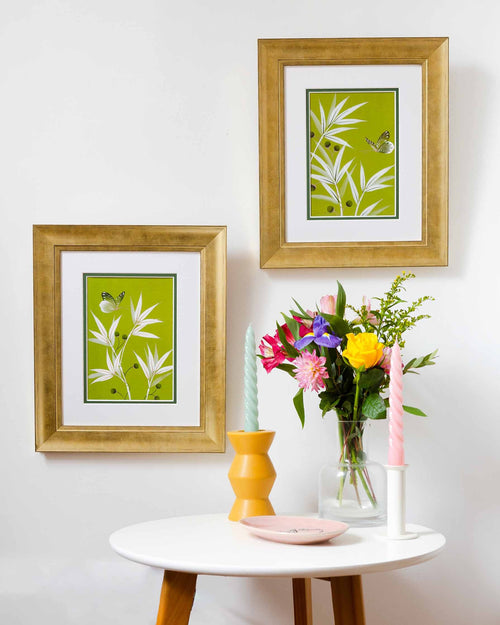 A set of 2 green botanical chinoiserie art prints featuring bamboo and butterflies framed with gold frame