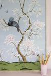 framed blue chinoiserie wall art print featuring a bird, flowers, and butterflies in Chinese painting style