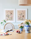 blush pink framed chinoiserie wall art prints featuring vintage style birds, butterfly and flower branches with a bamboo background hung on wall