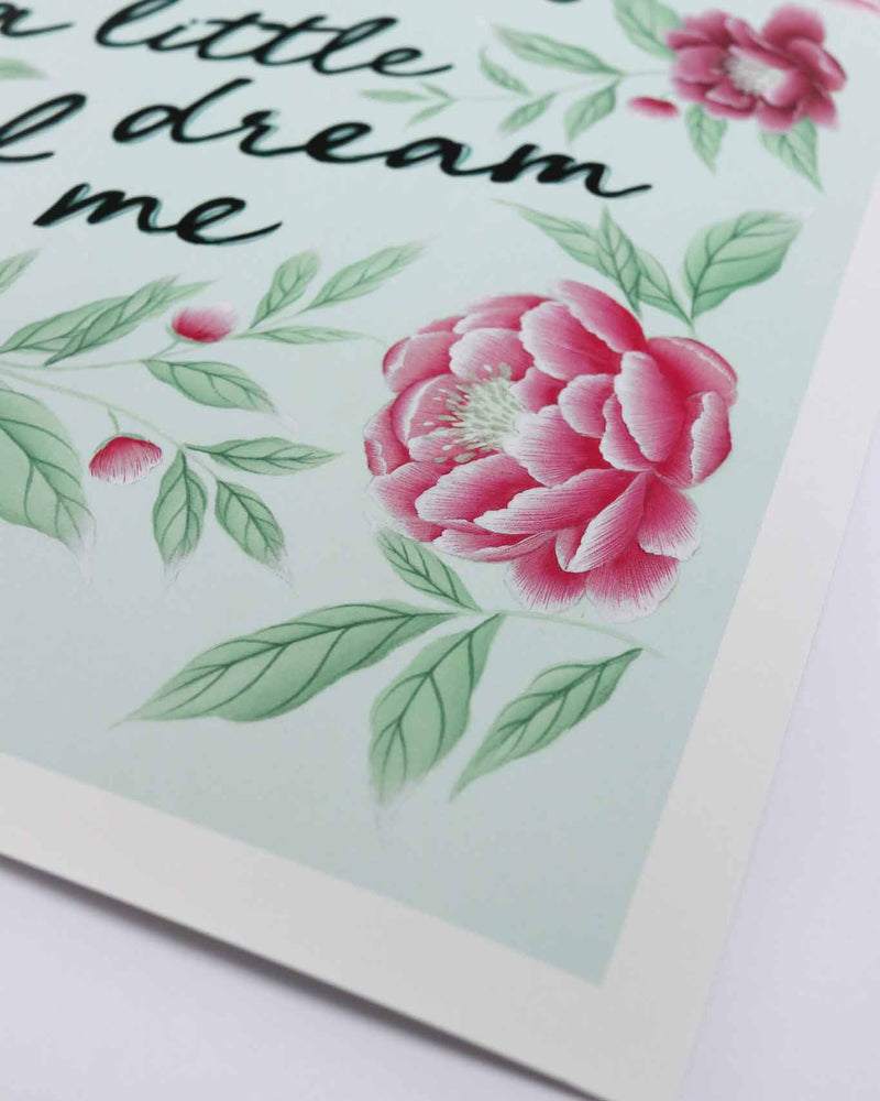 close up of blue and pink vintage-style chinoiserie wall art print featuring flowers and leaves with the quote 'dream a little dream of me'
