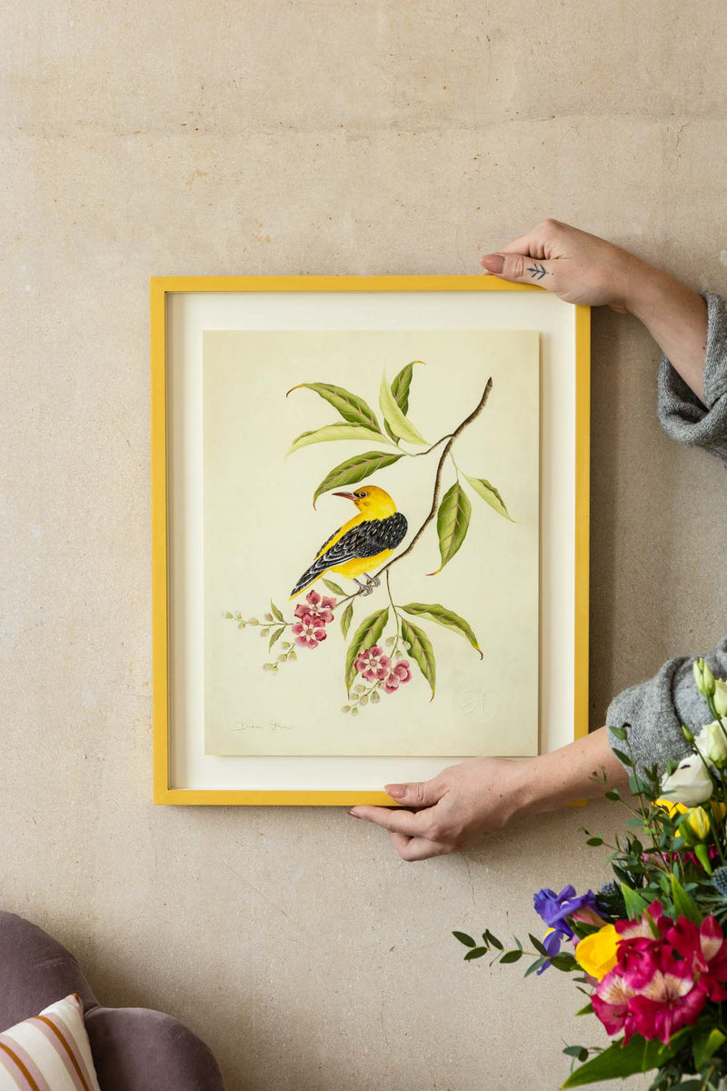 framed botanical wall art print featuring gold sparkle embellished exotic bird on tree branches with flowers hung on wall