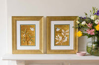 pair of framed chinoiserie wall art print featuring vintage Chinese-style butterfly and flower branch on gold background on mantle