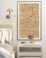 framed chinoiserie wall art print featuring Japanese-style cherry blossom and branches in bronze, burgundy and white tones hung on wall