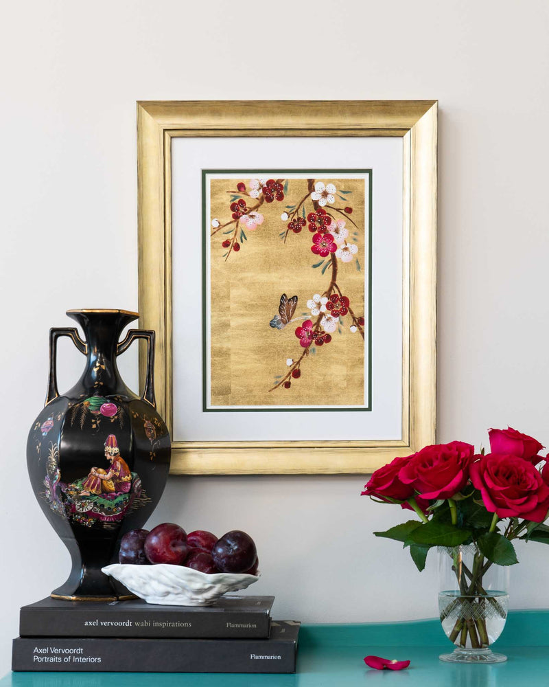 framed chinoiserie wall art print featuring Japanese-style cherry blossom branch and butterfly on gold leaf background hung on wall