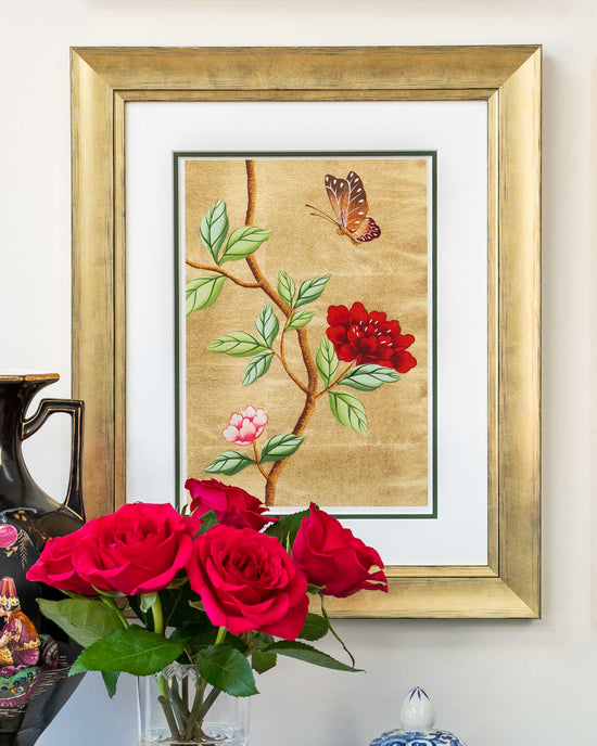 framed chinoiserie wall art print featuring vintage-style butterfly and flower branch on gold leaf background hung on wall