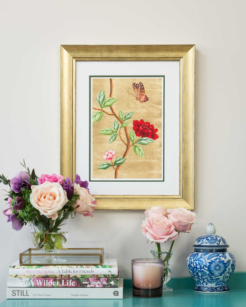 framed chinoiserie wall art print featuring vintage-style butterfly and flower branch on gold leaf background hung on wall