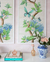 close up of pair of framed Chinoiserie style art prints featuring butterflies and blue flowers on an ivory cream background hung on wall