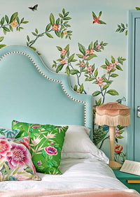 blue classic chinoiserie wallpaper featuring chinese illustration style peacocks, birds, and botanicals in maximalist bedroom