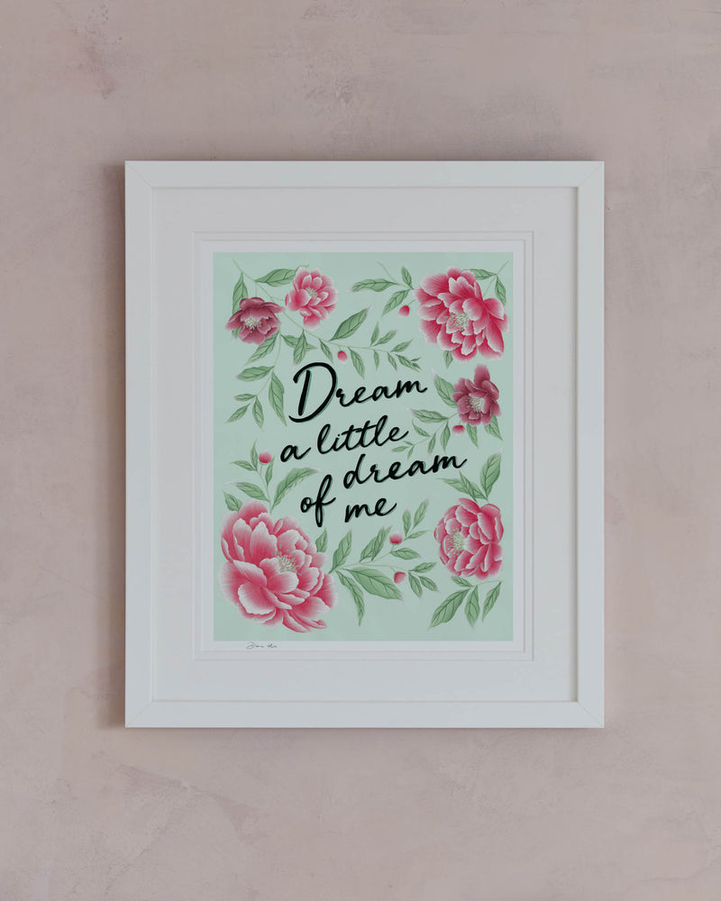 framed blue and pink vintage-style chinoiserie wall art print featuring flowers and leaves with the quote 'dream a little dream of me' hung on wall