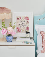 Dream a little dream charity chinoiserie art print by Diane Hill rests upon a bedside table set with candles and flowers
