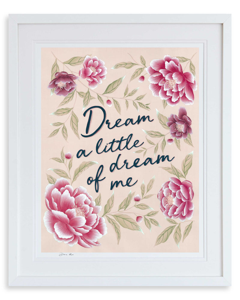 Dream a Little Dream charity art print by Diane Hill in pink, framed in a classic white frame. This charity art print features hand painted lyrics set against a pink background, woven with delicate sage green leaves and blooming pink peonies