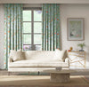 blue botanical fabric featuring chinoiserie style birds, branches, and butterflies on curtains in modern living room