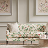 botanical fabric featuring chinoiserie style birds, branches, and butterflies on sofa in modern living room