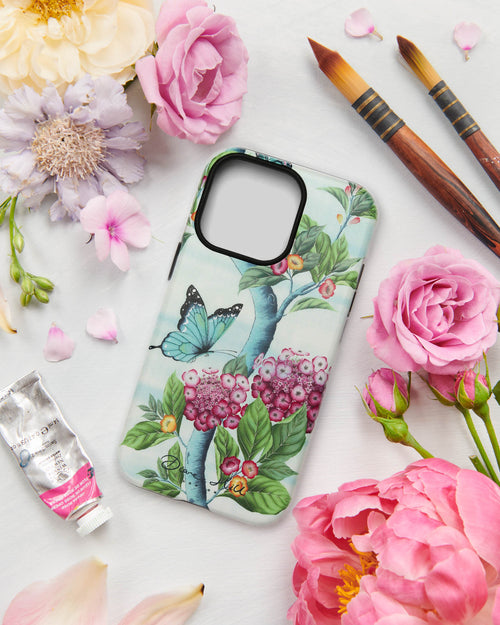 A pretty floral phone case in blue tones featuring pink hydrangea flowers and delicately painted butterflies