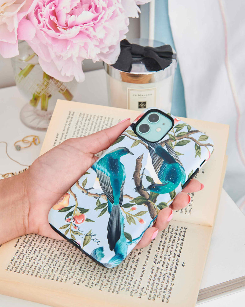 A hand holds the Felicity phone case by Diane Hill, with peonies in the background. The Felicity phone case design brings a little bit of paradise and faraway Eastern magic to your everyday look! A riot of bright, beautiful colour, rich botanicals and exquisitely-feathered birds, Felicity is a celebration of the beauty of nature.