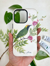 hand holding Luxury phone case featuring vintage style botanical bird on tree branch with flowers