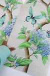 hand holding Chinoiserie style art prints featuring butterflies and blue flowers on an ivory cream background