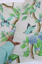 A close up of the luxurious print quality of Diane Hill's Chinoiserie art prints. This design features large blue butterflies, botanical green leaves and delicately painted blue hydrangea flowers