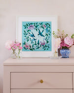 blue framed chinoiserie wall art print featuring three vintage inspired birds surrounded by leaves and flowers on set of drawers
