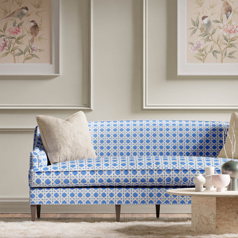 blue geometric fabric featuring chinoiserie trellis design on sofa in modern living room