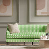 green geometric fabric featuring chinoiserie trellis design on sofa in modern living room