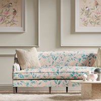 pink and blue botanical fabric featuring chinoiserie style fruits and flowers on sofa in modern living room