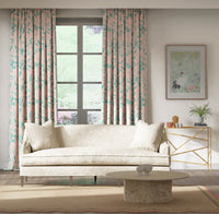 pink and blue botanical fabric featuring chinoiserie style fruits and flowers on curtains in modern living room