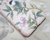 close up of pink luxury phone case featuring vintage style bird, butterfly and flower branches with a bamboo background