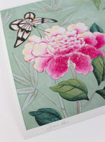 close up of colourful chinoiserie wall art print featuring bird, flowers, and butterfly on blue background