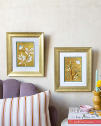 pair of framed chinoiserie wall art print featuring vintage Chinese-style butterfly and flower branch on gold background hung on wall