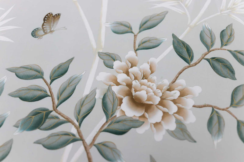 close up of pebble blue chinoiserie wall art print featuring butterflies, flower branches, and bamboo