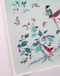 close up of blue chinoiserie art print featuring colourful birds on blossom branch, butterflies and fruit