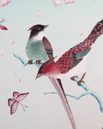close up of blue chinoiserie art print featuring colourful birds on blossom branch, butterflies and fruit