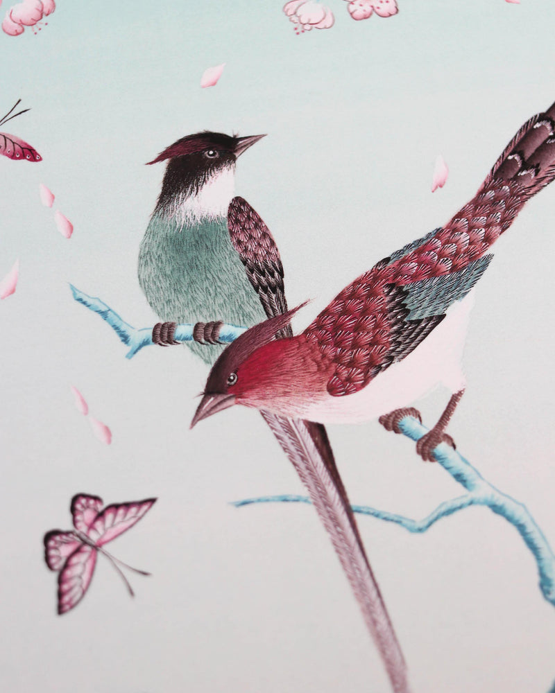 close up of blue chinoiserie art print featuring colourful birds on blossom branch, butterflies and fruit